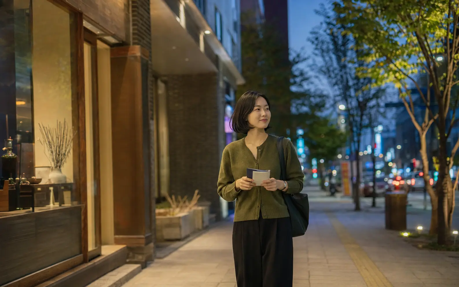 인계동 나혜석거리에서 작은 프로그램 책자를 든 20대 성인 여성 로컬 에디터 지은